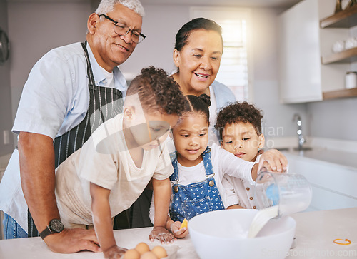 Image of Try to get it all in okay. a mature couple baking with their grandkids at home.