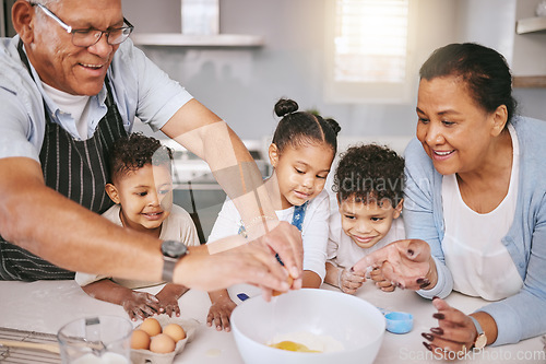 Image of One egg holds it all together. a mature couple baking with their grandkids at home.