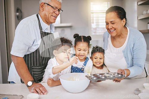 Image of Each on gets a turn. a mature couple baking with their grandkids at home.