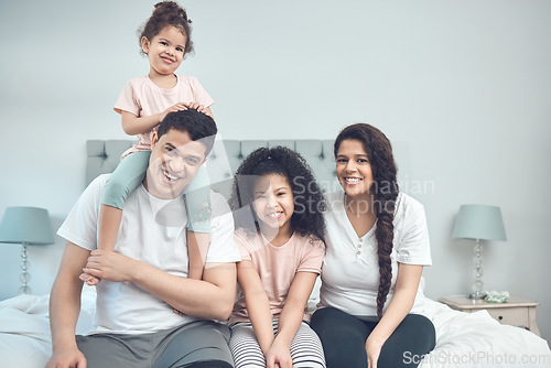 Image of Every void filled. Portrait of a beautiful young family talking and bonding while sitting on a bed together.