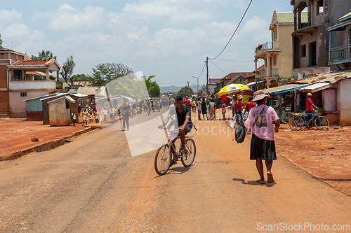 Image of Candid street photography of local residents walking and going about their daily lives on Mandoto street in Madagascar.