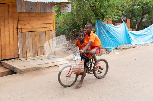 Image of Two Malagasy boys on one bike. Mandoto, Madagascar