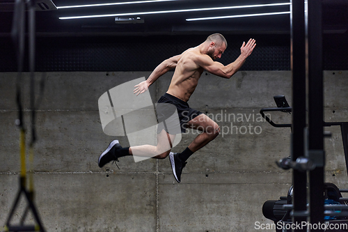 Image of A muscular man captured in air as he jumps in a modern gym, showcasing his athleticism, power, and determination through a highintensity fitness routine