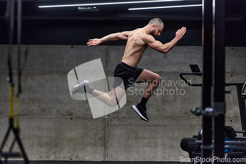 Image of A muscular man captured in air as he jumps in a modern gym, showcasing his athleticism, power, and determination through a highintensity fitness routine