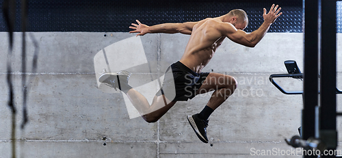 Image of A muscular man captured in air as he jumps in a modern gym, showcasing his athleticism, power, and determination through a highintensity fitness routine