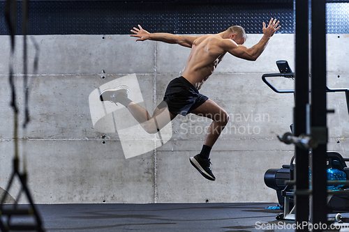 Image of A muscular man captured in air as he jumps in a modern gym, showcasing his athleticism, power, and determination through a highintensity fitness routine