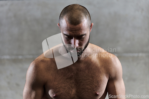 Image of A muscular man poses in the gym, showcasing his strength and dedication to fitness through an impressive physique and glistening sweat on his face.