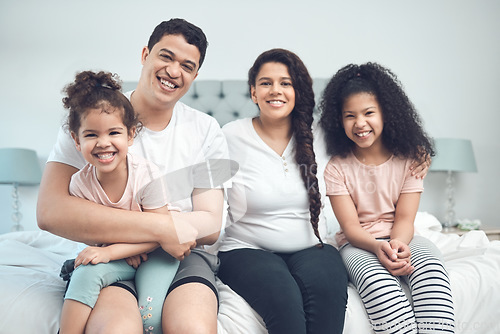 Image of Never to be destroyed. Portrait of a beautiful young family talking and bonding while sitting on a bed together.