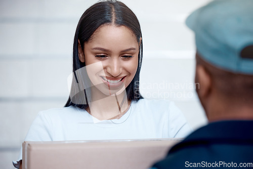 Image of I cant wait to open this. a young woman receiving her delivery from the courier.