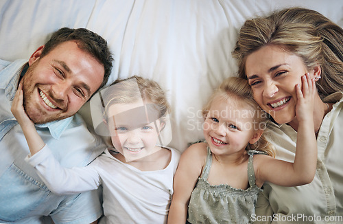 Image of A family that lays together, stays together. Portrait of a beautiful young family talking and bonding in bed together.