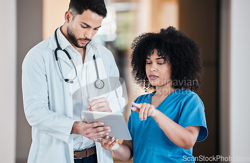 Image of Leave the planning to the pros. two young doctors using a tablet and having a discussion in a modern office.