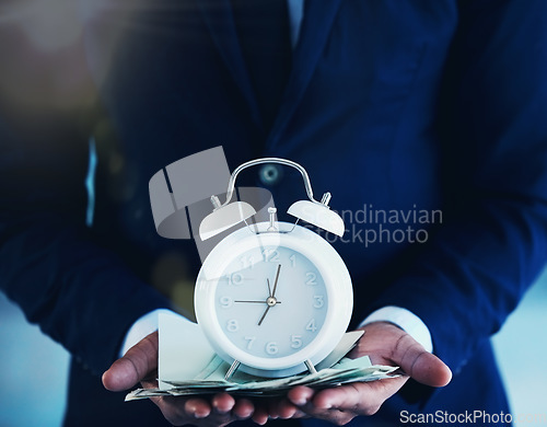 Image of Time is precious. an unrecognisable businessman standing alone in the office and holding an alarm clock.