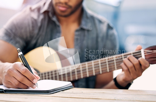 Image of Composing new music. an unrecognizable man playing guitar.