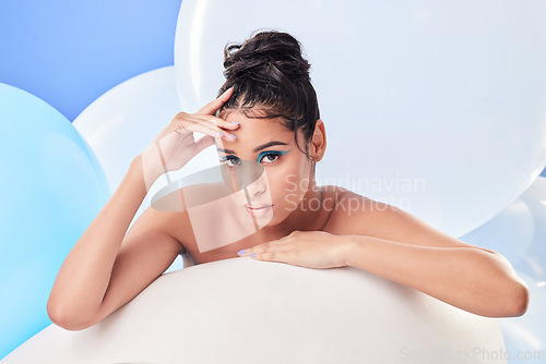 Image of For my birthday, Im having a private party for one. Studio shot of an attractive young woman posing with balloons against a blue background.