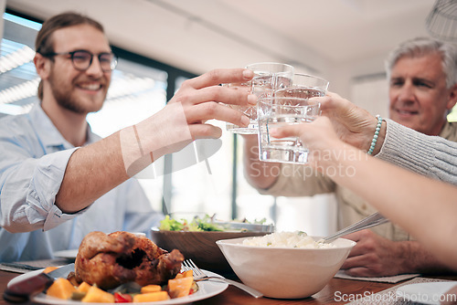 Image of Cheers to family and togetherness through the years. a family toasting with drinks while having a meal together at home.