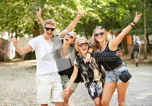 Image of Friends and parties. Four friends partying and celebrating at a music festival.