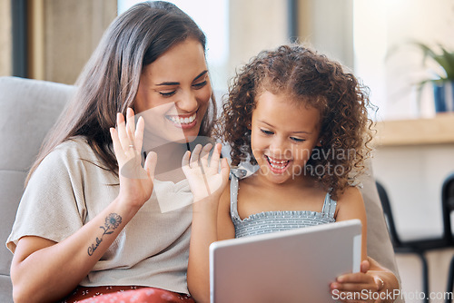 Image of Hispanic mother and little daughter waving with a hand gesture while using a digital tablet for a video call at home. Little girl and woman greeting someone on a call while smiling