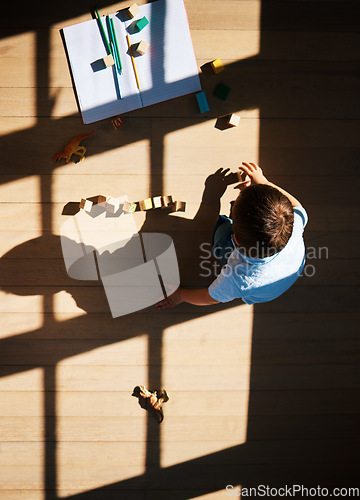 Image of Top view of little toddler boy playing with wooden colorful building blocks sorting shapes. Child learning skills, creativity and imagination development game. Learn when play