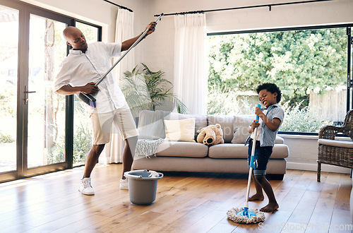 Image of Dad and son having fun while cleaning at home. African american father and boy playing air guitar with mop and broom while cleaning living floor. Making chores fun