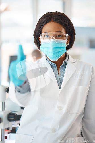 Image of All is on track with my experiments. Portrait of a young scientist showing thumbs up in a lab.