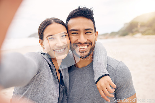 Image of Training and gaining together. Portrait of a sporty young couple taking selfies while exercising together on the beach.