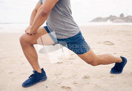 Image of Get your legs ready for it. Closeup shot of an unrecognisable man stretching his legs while exercising on the beach.