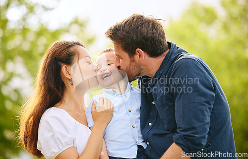Image of A kiss for our cutie. a young family spending time together at the park.