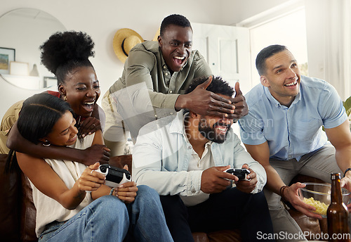 Image of Weve got money on this game. two people playing video games while sitting at home with their friends.