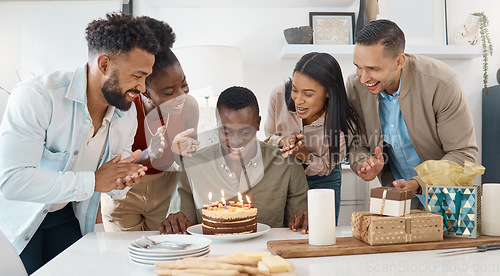 Image of Awkwardly looking at my cake while they sing for me. a young man celebrating his birthday with friends at home.