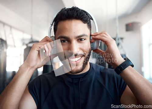 Image of Now Im pumped. Portrait of a sporty young man listening to music while exercising in a gym.