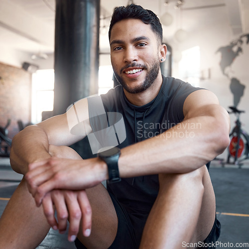 Image of Its important to take breaks in between sets. Portrait of a sporty young man taking a break while exercising in a gym.