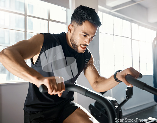 Image of The more you beast, the more you gain. a sporty young man working out on an exercise bike in a gym.