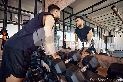 Image of If you can face yourself, you can face anything. a sporty young man looking at himself in a mirror while exercising in a gym.