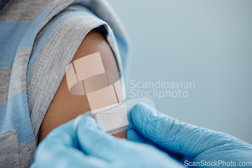 Image of Vaccinated to stay protected from certain infectious diseases. Closeup shot of an unrecognisable doctor applying a plaster to a little boys arm after an injection.