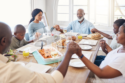 Image of A moment of silence. a beautiful family blessing the food with a prayer at the table together at home.