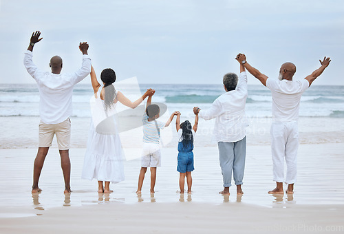 Image of Jump on three. Rearview shot of a family spending the day at the beach together.