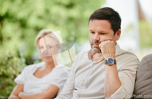 Image of Sad man looking disappointed and ignoring wife after argument. Middle aged man thinking about divorce after fight and having relationship troubles