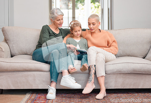 Image of At ease with mom. a mature woman bonding with her daughter and granddaughter while using a digital tablet.