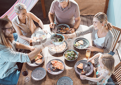 Image of Would you like some. High angle shot of a family sitting together and enjoying lunch.