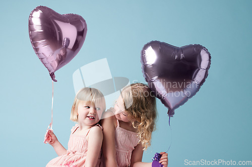 Image of You deserve all the love. two cute sisters playing with heart balloons against a studio background.