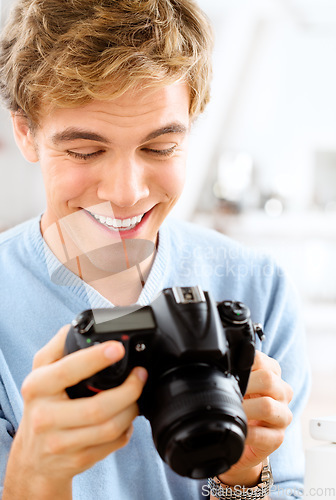 Image of These are perfect. a young man using his digital camera at home.