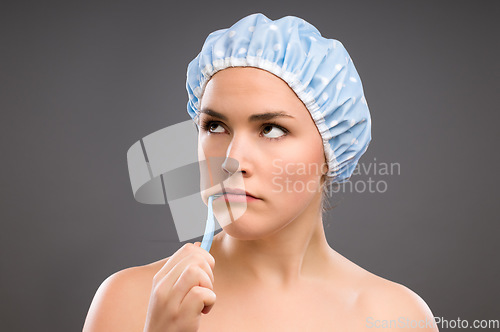 Image of This is the last thing I wanted to do. a young woman brushing her teeth against a studio background.