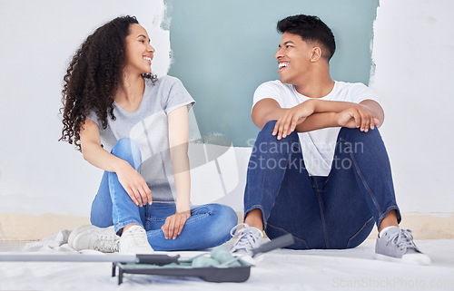 Image of Were always ready for a challenge. a young couple painting a wall in a room together.