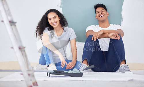 Image of We decided to paint the house ourself. a young couple painting a wall in a room together.