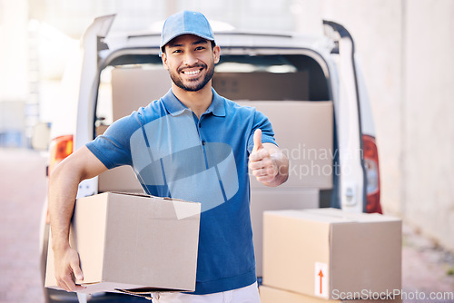 Image of To give real service you must add something. Portrait of a young delivery man showing thumbs up while holding a box.