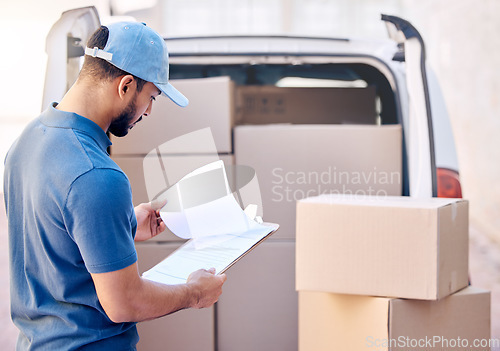 Image of You earn loyalty day-by-day. a delivery man standing by his van.