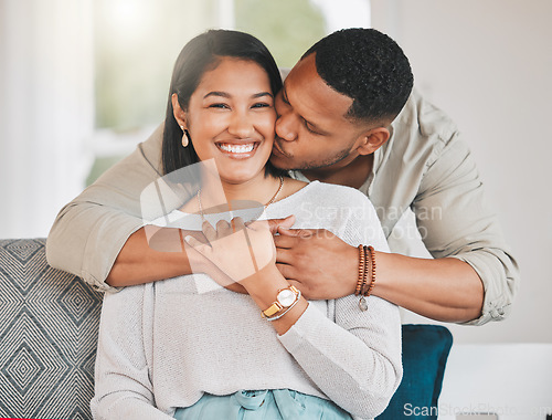 Image of He always showers me in so much love. a young man giving his wife a kiss on the cheek at home.