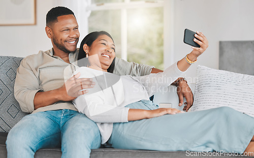 Image of Husband dearest, come take a selfie with me. a young couple taking selfies while relaxing together at home.
