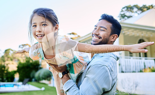 Image of Dad always encourages me to do whatever i want. a young father holding up his daughter in the garden outside.