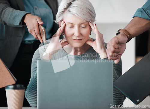 Image of These interns will be the death of me. a senior businesswoman sitting in the office and feeling stressed while her colleagues put pressure on her.